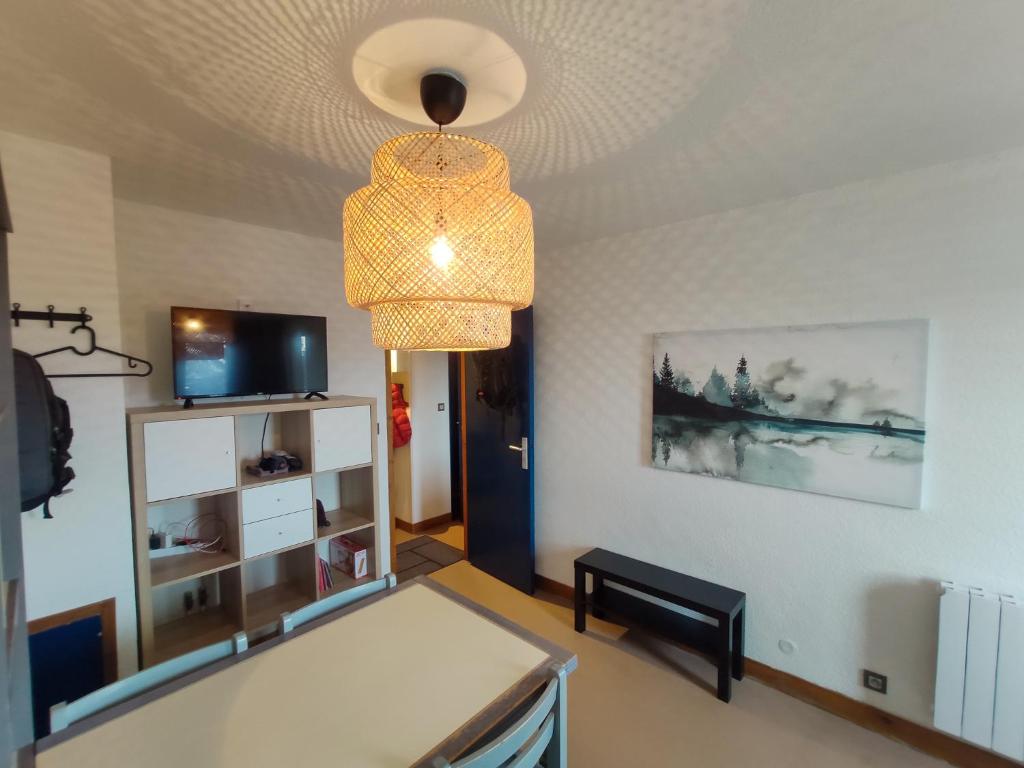 un salon avec un lustre suspendu au plafond dans l'établissement Val Louron Pied des pistes apartment 34 m² 5 pers, à Génos