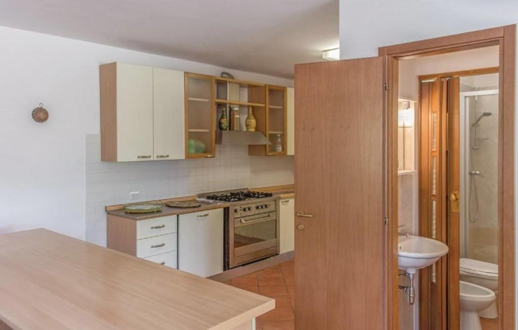 La cuisine est équipée de placards blancs et d'un évier blanc. dans l'établissement Villa Brenda by VacaVilla, à Pratovecchio