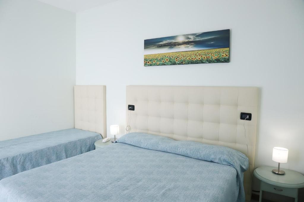 une chambre avec deux lits et un tableau au mur dans l'établissement Hotel La Bussola, à Lido di Jesolo