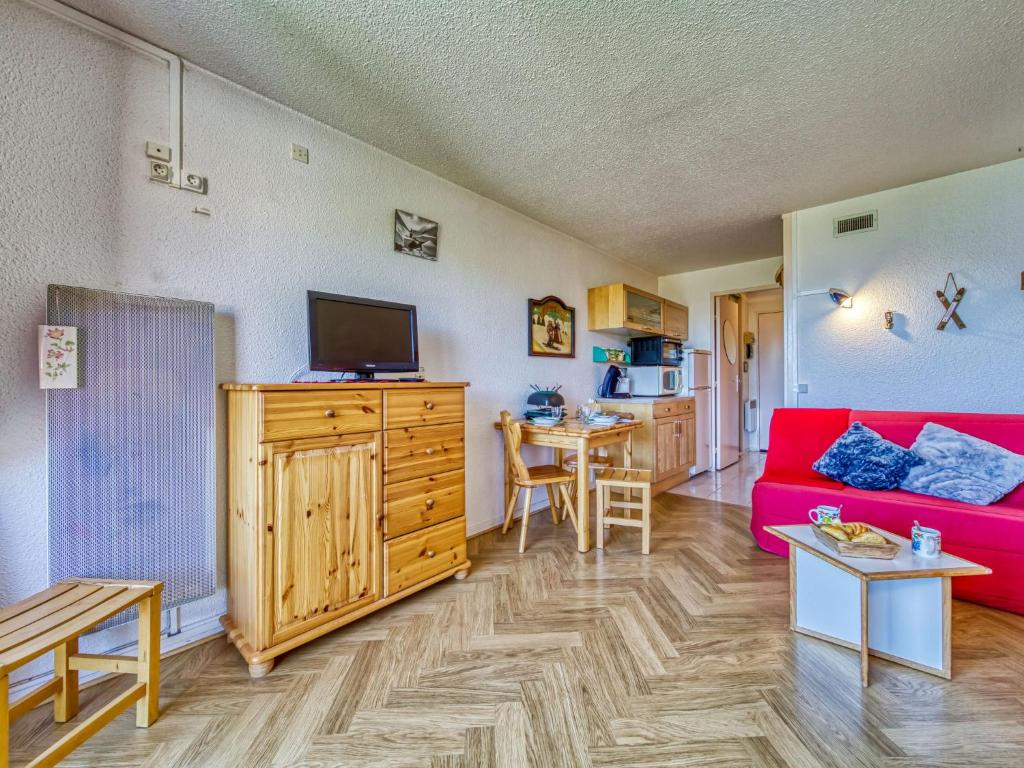 un salon avec un canapé rouge et une cuisine dans l'établissement Studio Lunik Orion-49 by Interhome, au Corbier 36 autres photos