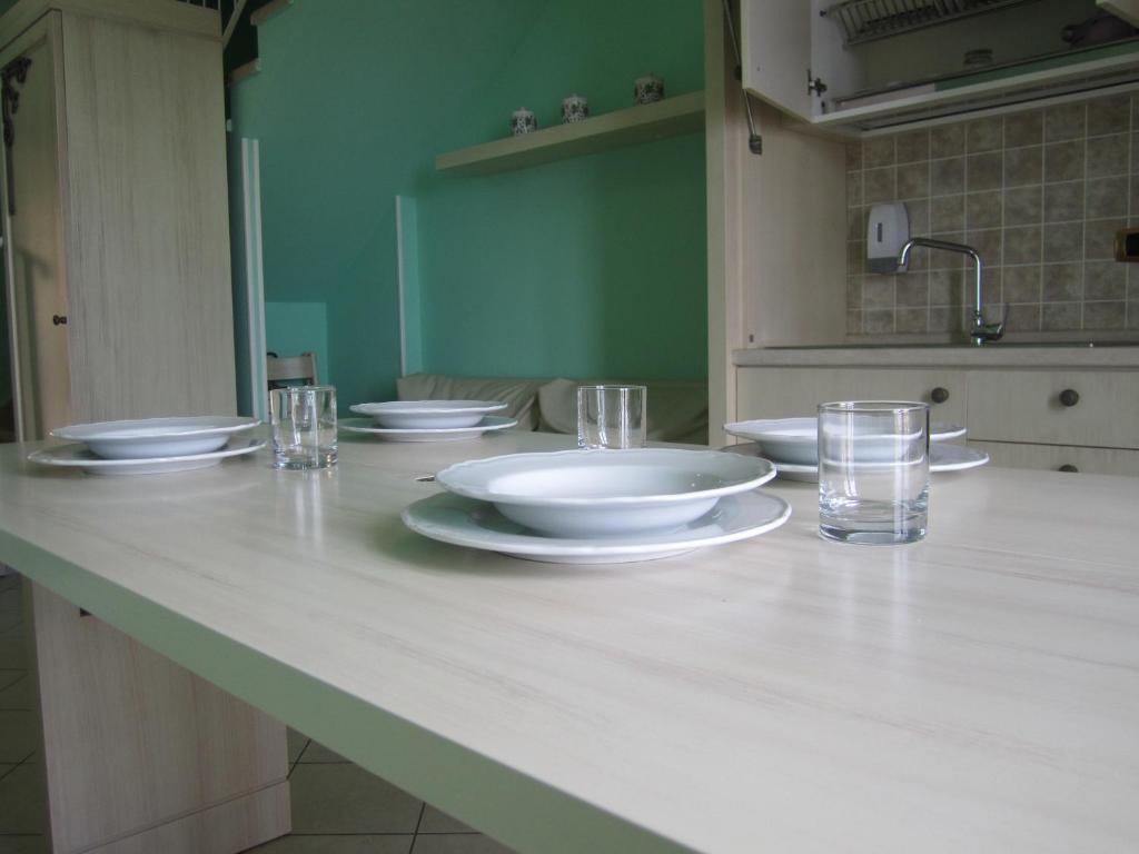 - un comptoir de cuisine avec des assiettes blanches et des verres dans l'établissement Palazzo Reginella, à Bovalino Marina 59 autres photos