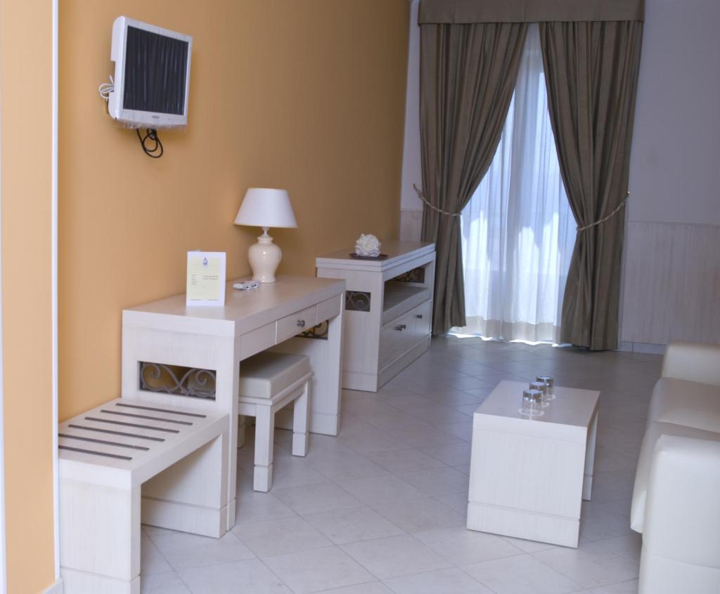 Cette chambre blanche dispose d'un bureau et d'une télévision. dans l'établissement Palazzo Reginella, à Bovalino Marina