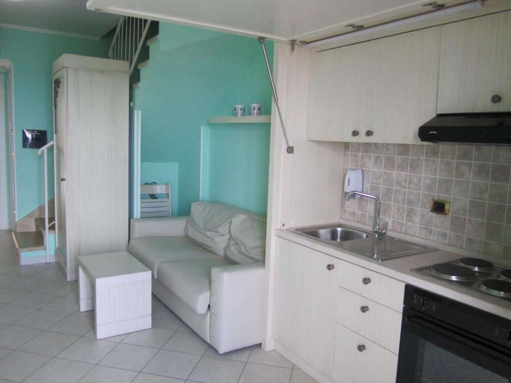une petite cuisine avec un canapé et un évier dans l'établissement Palazzo Reginella, à Bovalino Marina
