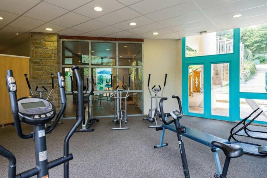 une salle de sport avec plusieurs tapis de course et machines elliptiques dans l'établissement T1 bis A CAUTERETS - 4 VOYAGEURS, à Cauterets