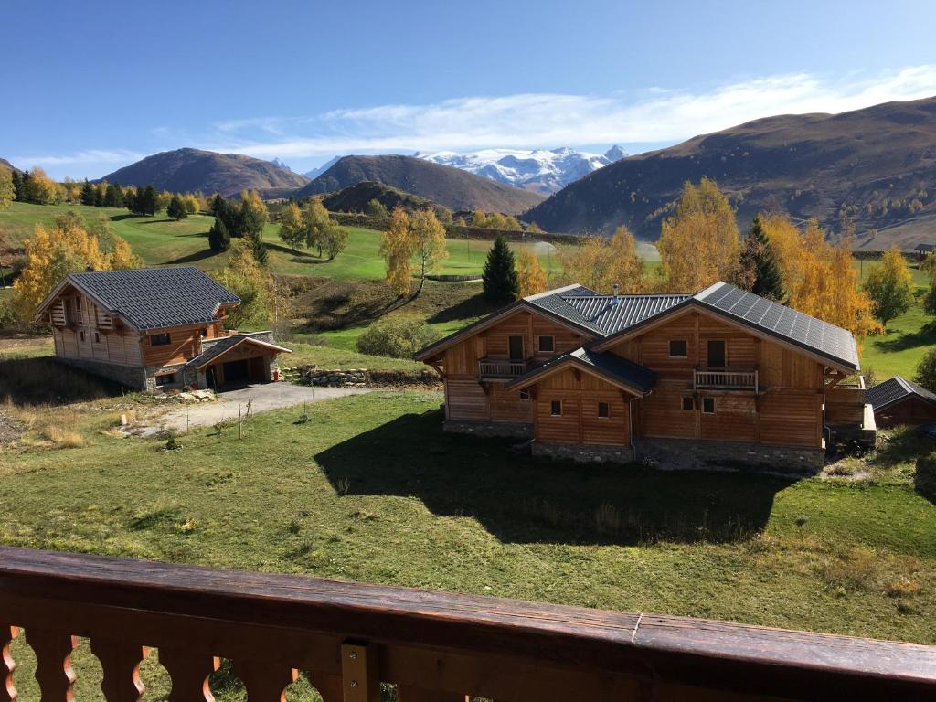 une maison sur une colline avec des montagnes en arrière-plan dans l'établissement Appartement 5 pers Résidence Les Mélèzes quartier les Bergers Alpe d Huez, à L'Alpe-d'Huez 10 autres photos