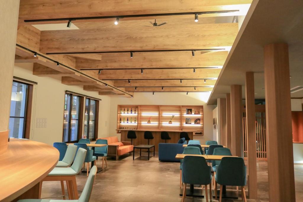d'une salle à manger avec des tables et des chaises et des plafonds en bois. dans l'établissement Awazuonsen Kitahachi, à Komatsu