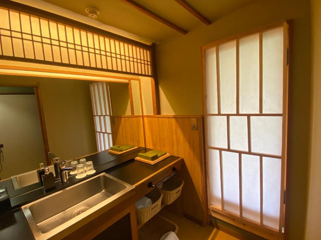 une salle de bain avec un lavabo et un miroir dans l'établissement Wakamatsu HakoneYugawara, à Yugawara