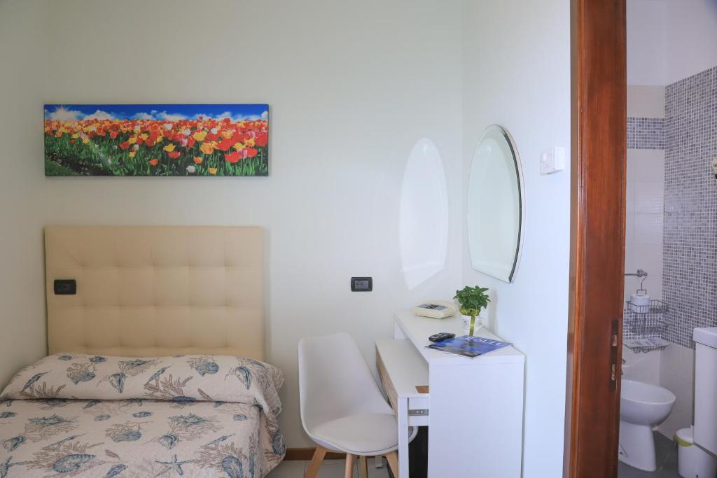 une chambre avec un lit, un lavabo et un miroir dans l'établissement Hotel La Bussola, à Lido di Jesolo