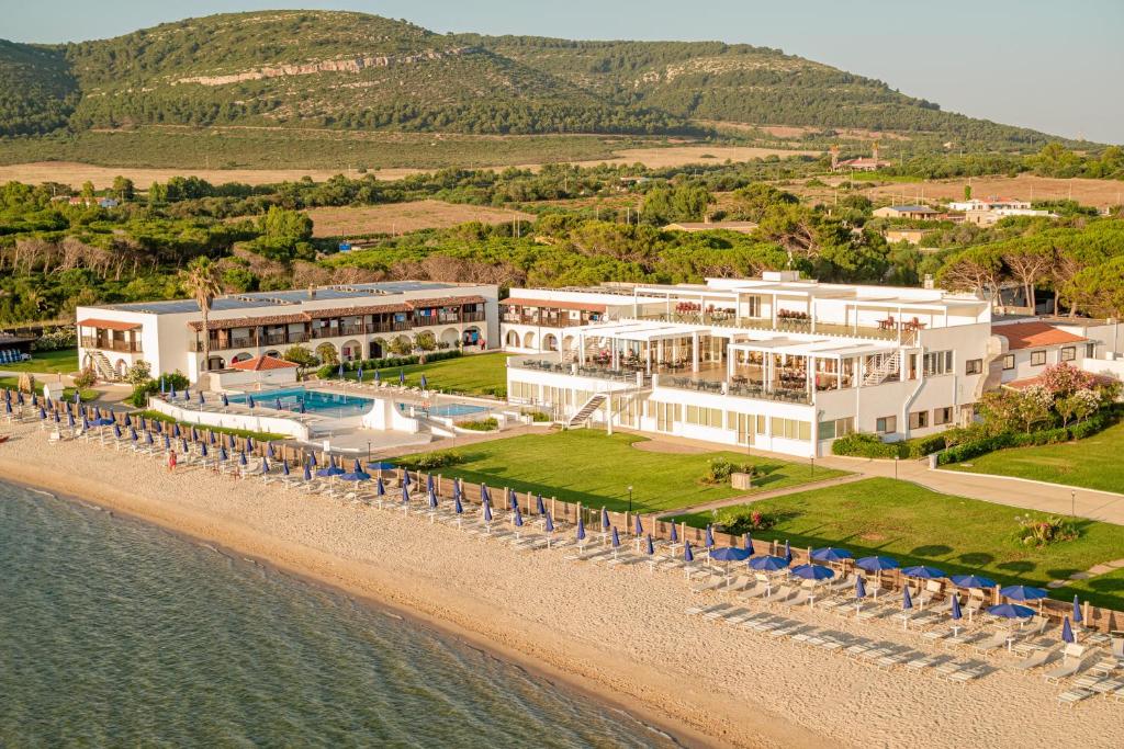 une vue aérienne d'un complexe hôtelier sur la plage dans l'établissement Hotel Portoconte, à Porto Conte