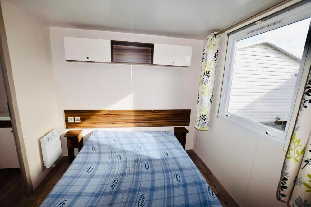 une petite chambre avec un lit et une fenêtre dans l'établissement Les Pierres Couchées 4 étoiles à St Brévin les Pins emplacement BR22 3CH 2SDB 8 personnes, à Saint-Brévin-les-Pins 5 autres photos