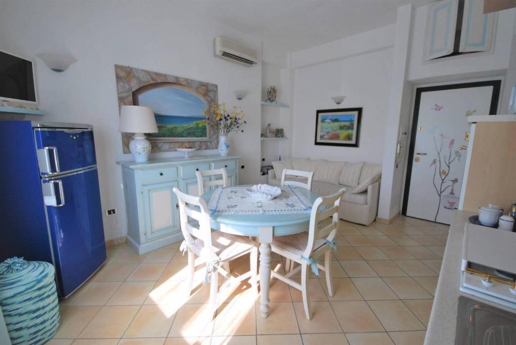 une cuisine avec une table et des chaises dans une pièce dans l'établissement Recidence gallo di Gallura Casa Azzurra, à Santa Teresa Gallura