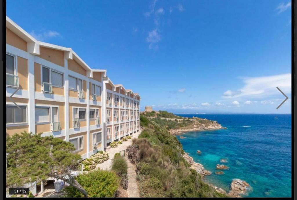 - un bâtiment sur une falaise à côté de l'océan dans l'établissement Recidence gallo di Gallura Casa Azzurra, à Santa Teresa Gallura