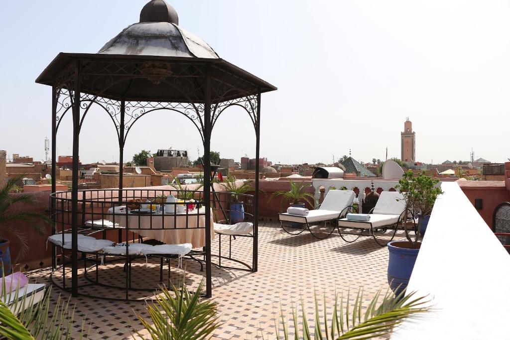 - un kiosque sur le toit avec des chaises blanches dans l'établissement Riad Tahar Oasis, à Marrakech