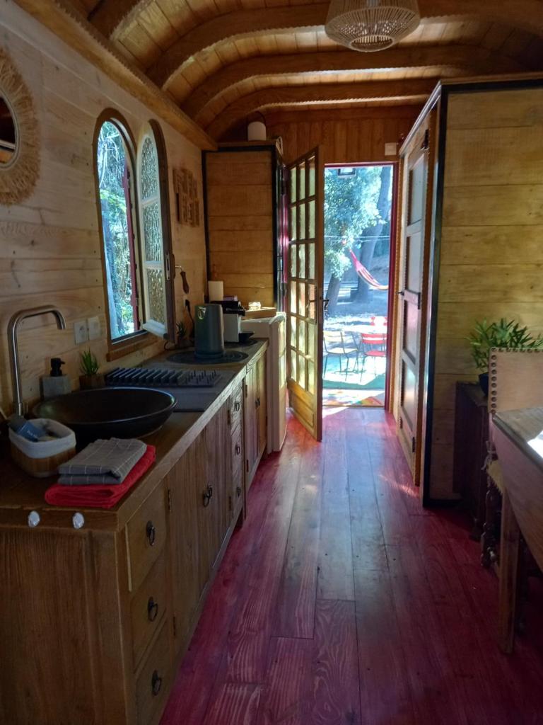 Il comprend une cuisine avec des placards en bois et du parquet. dans l'établissement La roulotte du petit paradis, à Saint-Rémy-de-Provence