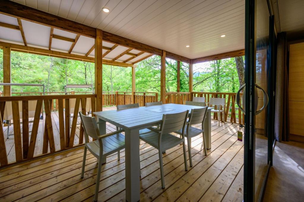 une terrasse couverte avec une table et des chaises. dans l'établissement Le Clos de Barbey, à Bauduen