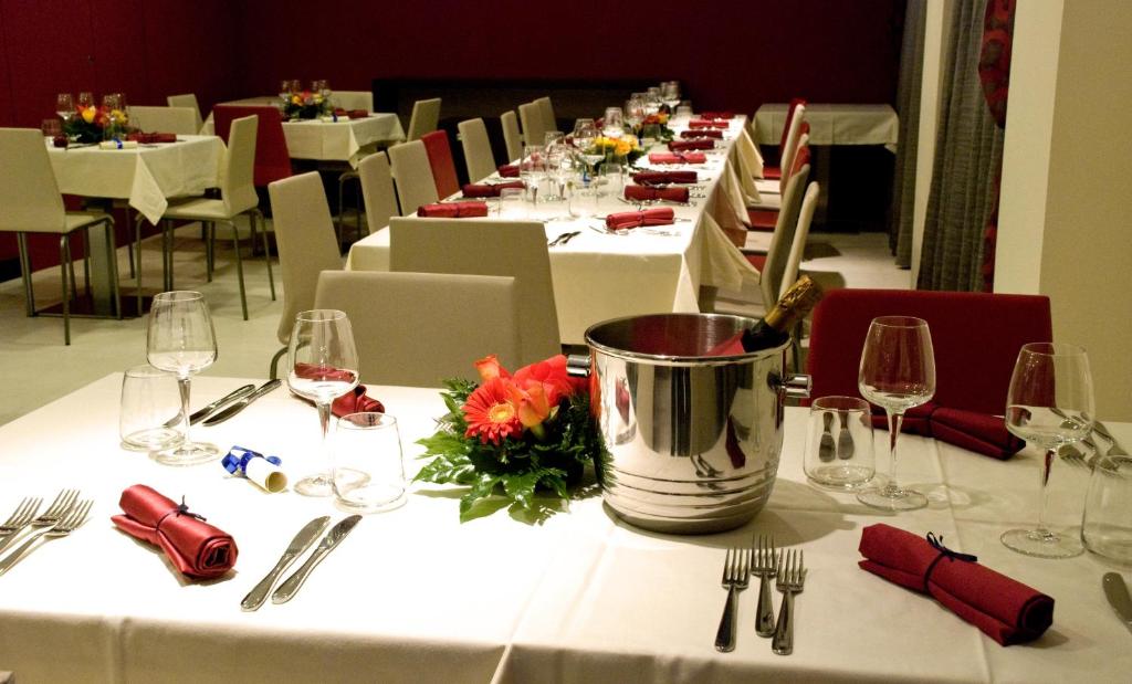 - une longue table avec des tables blanches et des verres à vin dans l'établissement La Isla Resort, à Pontecagnano