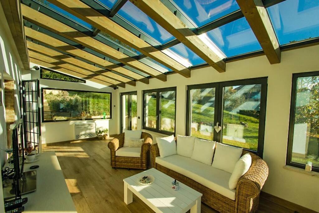 un salon avec un canapé, des chaises et des fenêtres dans l'établissement Tofelli villa with private pool, quiet and panoramic view, à Amelia