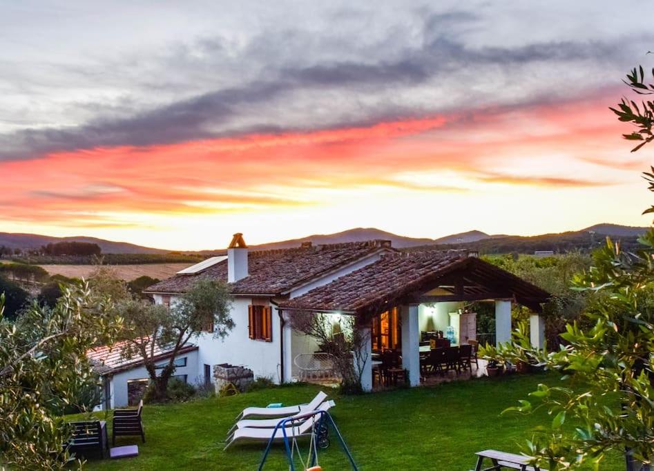 une maison avec des chaises et un coucher de soleil en arrière-plan dans l'établissement Tofelli villa with private pool, quiet and panoramic view, à Amelia