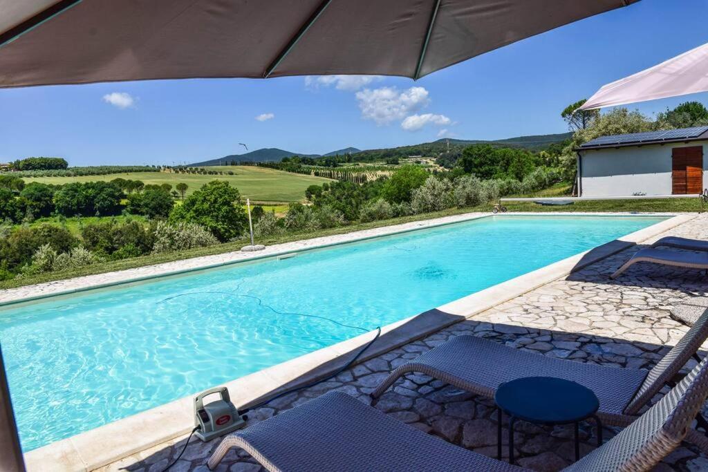 une piscine avec des chaises et un parasol dans l'établissement Tofelli villa with private pool, quiet and panoramic view, à Amelia