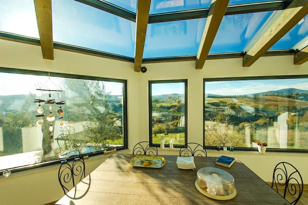 Cette grande chambre dispose d'une table et de grandes fenêtres. dans l'établissement Tofelli villa with private pool, quiet and panoramic view, à Amelia