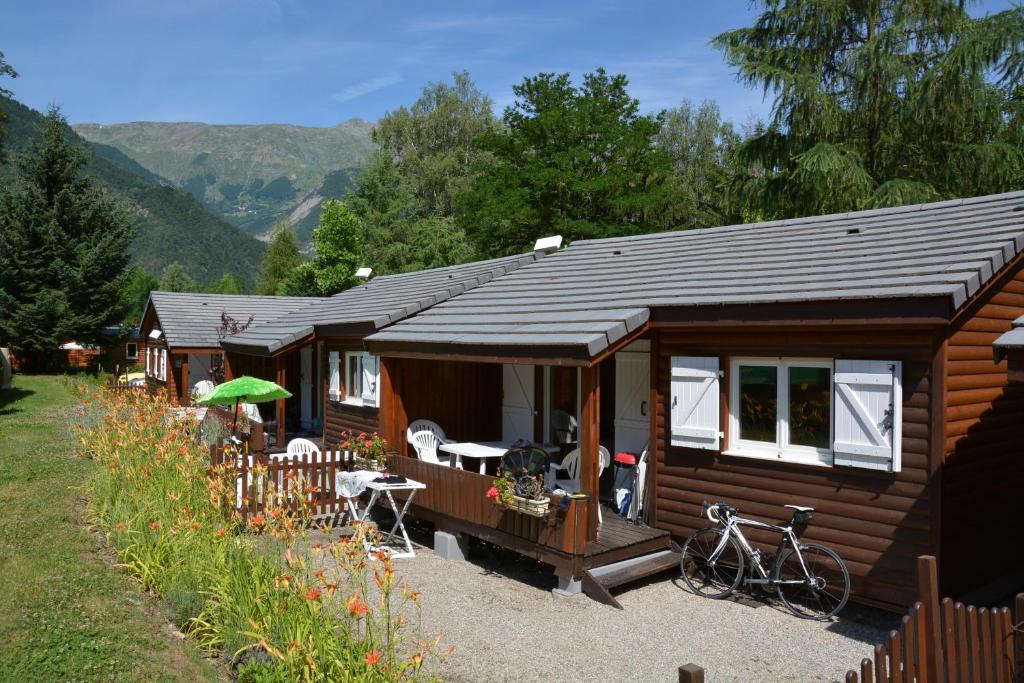 une cabine avec un vélo garé devant elle dans l'établissement A La Rencontre Du Soleil - Camping, au Bourg-dʼOisans