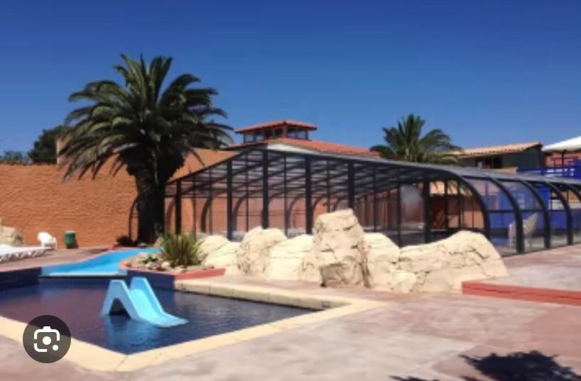 un complexe avec une piscine et un bâtiment dans l'établissement Mobil-home 5 personnes dans camping Mar Estang 4 étoiles avec accès à la plage, à Canet 19 autres photos