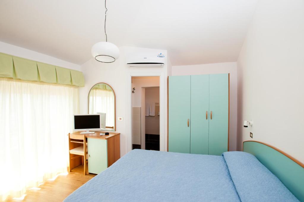 une chambre avec un lit et un bureau avec un ordinateur dans l'établissement Albergo Villa Mauri, à Rimini