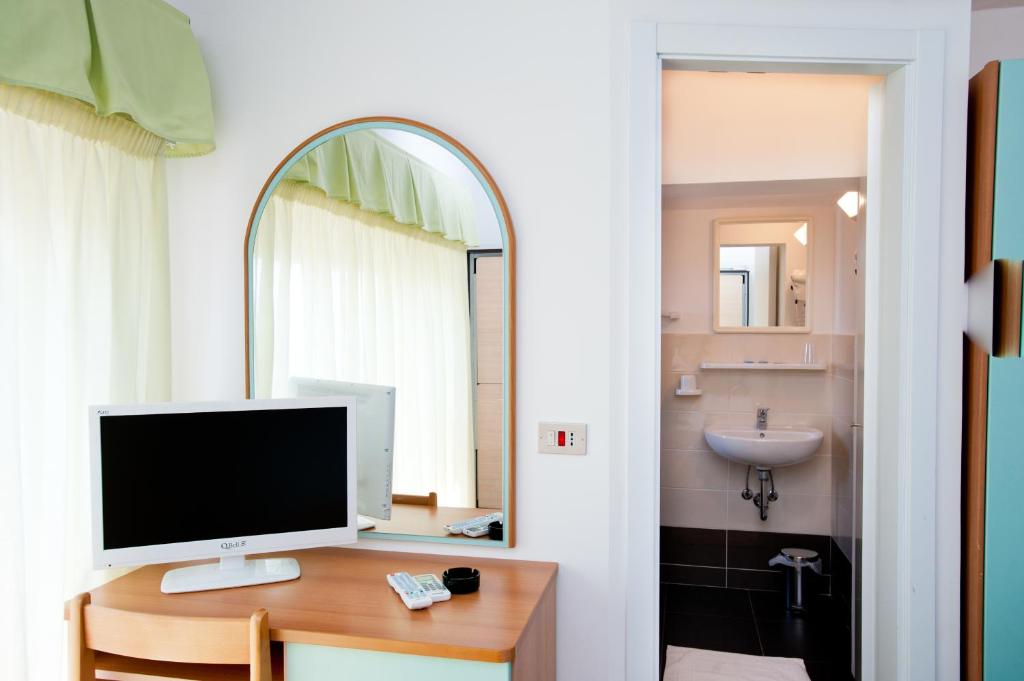 une pièce avec un ordinateur sur un bureau avec un miroir dans l'établissement Albergo Villa Mauri, à Rimini