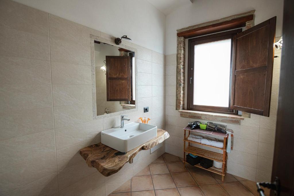 une salle de bain avec un lavabo et un miroir dans l'établissement CASALE RO, à Roccella Ionica