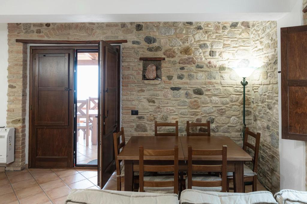 une salle à manger avec une table et un mur en pierre dans l'établissement CASALE RO, à Roccella Ionica
