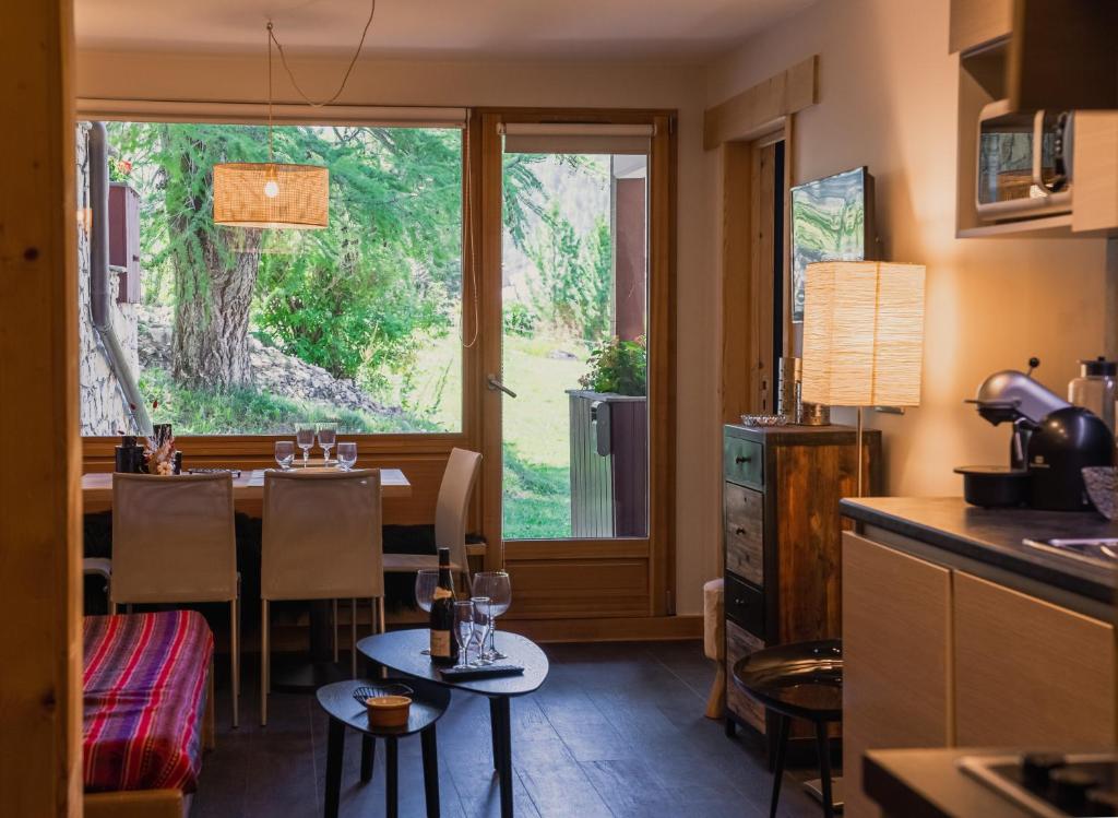 une cuisine et une salle à manger avec une table et une fenêtre dans l'établissement Maisons de montagne Le Samovar, à Val dʼIsère