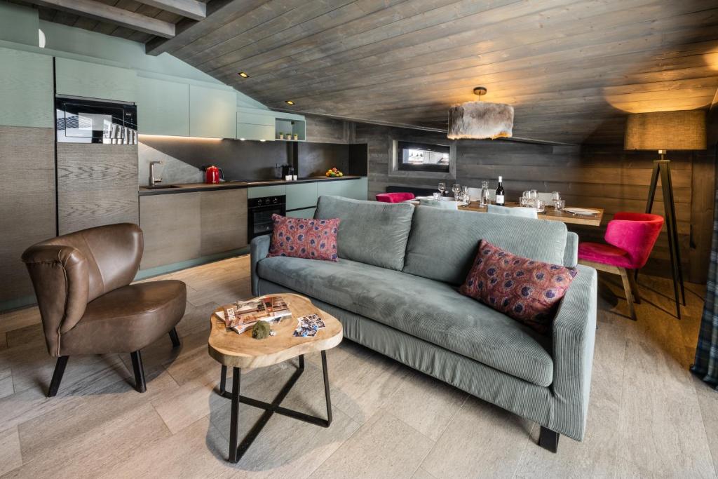 un salon avec un canapé et une table dans l'établissement Chalets Izia - Village Montana, à Val dʼIsère