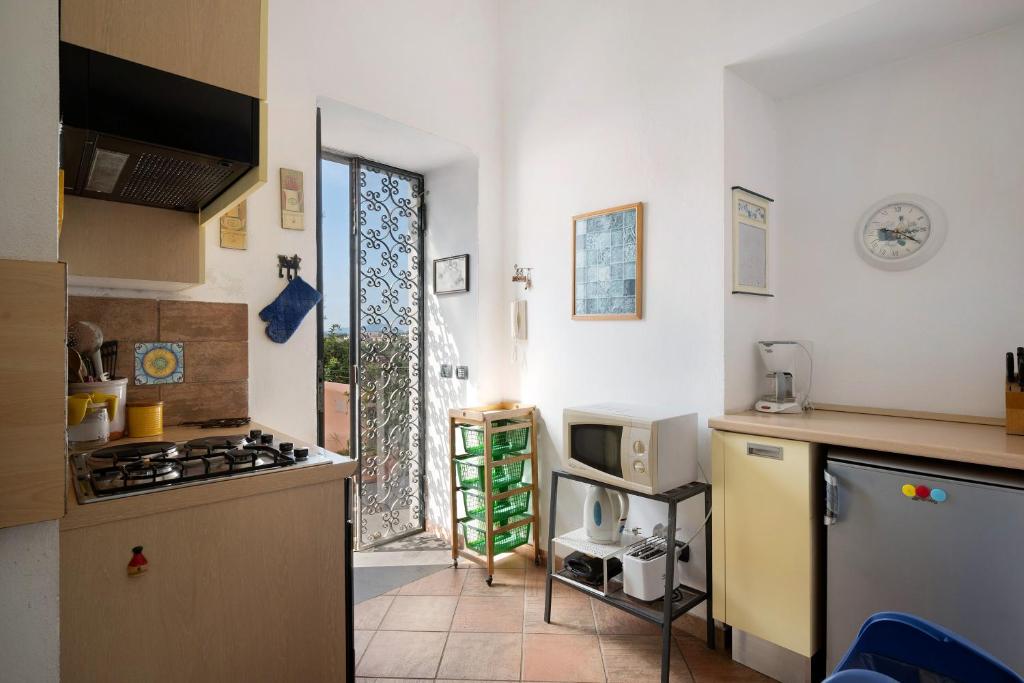 Il comprend une cuisine équipée d'une cuisinière. four supérieur à côté d'une fenêtre dans l'établissement Flegrea House, à Pouzzoles