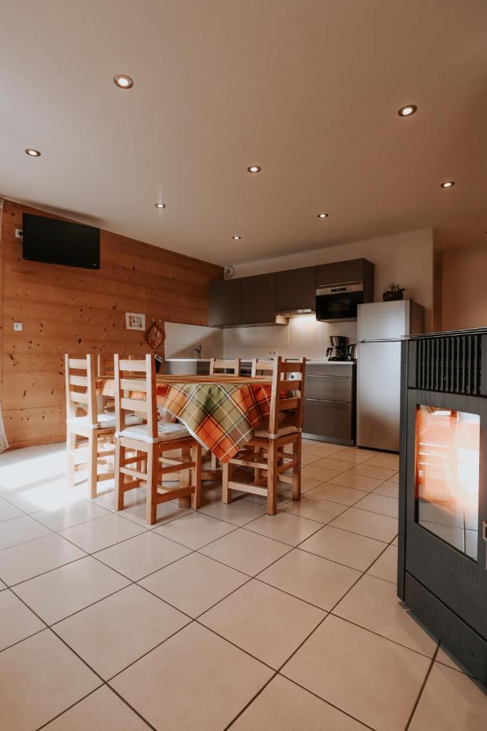 une cuisine avec une table et des chaises et une télévision dans l'établissement Chalet Les Hellebores, à La Toussuire 20 autres photos