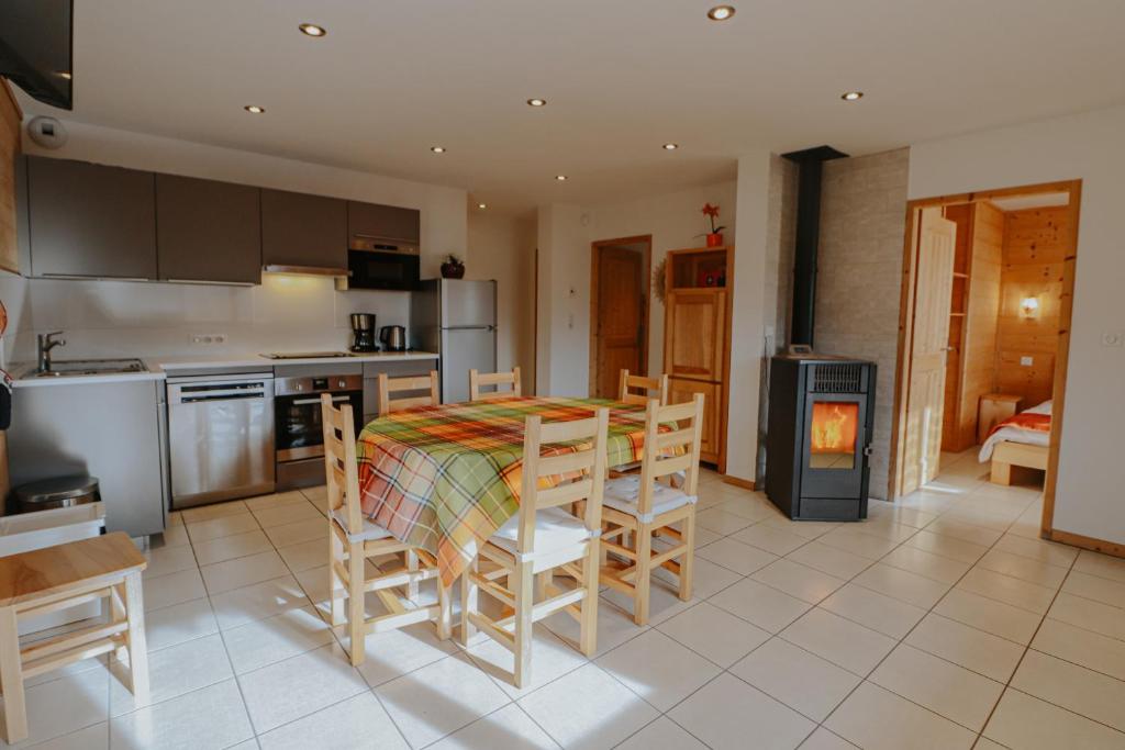 une cuisine et une salle à manger avec une table et des chaises dans l'établissement Chalet Les Hellebores, à La Toussuire