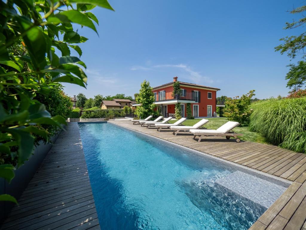 - une piscine avec des chaises longues à côté d'une maison dans l'établissement Luxury Golf Villa, à Bogogno