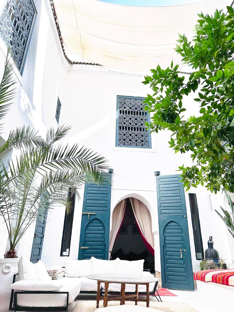 un bâtiment avec volets bleus, table et chaises dans l'établissement Berber Duchess Riad, à Marrakech