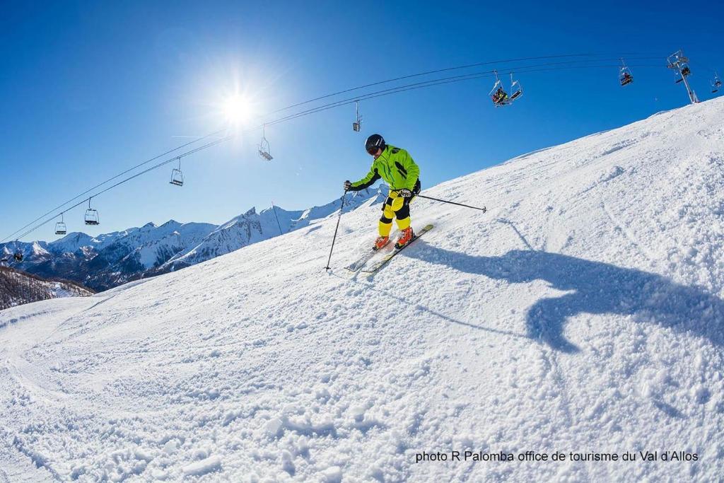 une personne skiera sur une piste enneigée sur une remontée mécanique dans l'établissement Studio chaleureux à la Foux D’Allos, à Allos