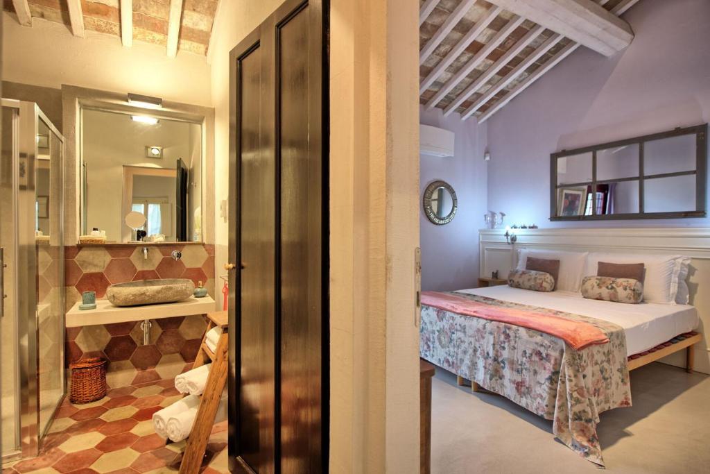 une chambre avec un lit et un miroir dans l'établissement Villa Tenuta Lonciano by PosarelliVillas, à Florence