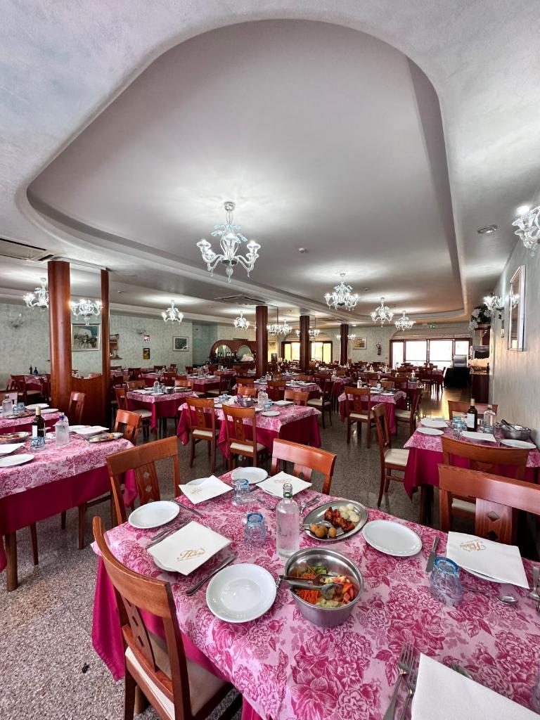 une salle à manger avec des tables et des chaises avec des nappes roses dans l'établissement Hotel Holiday, à Martinsicuro