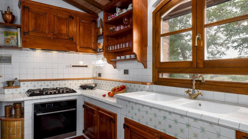 une cuisine avec un évier, une cuisinière et une fenêtre dans l'établissement VILLA BINETTI 7, Emma Villas, à San Gimignano