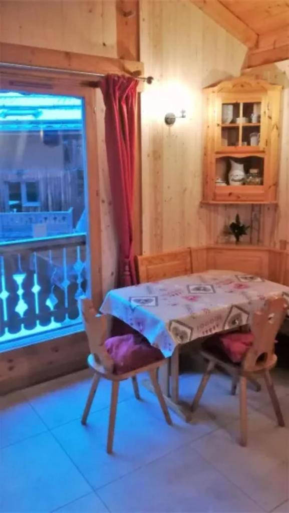 une table et des chaises dans une pièce avec une fenêtre dans l'établissement Le Tyrol, à La Plagne Tarentaise 6 autres photos