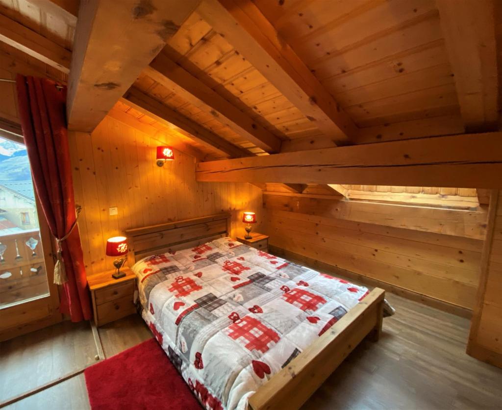 une chambre avec un lit dans une pièce en bois dans l'établissement Le Tyrol, à La Plagne Tarentaise
