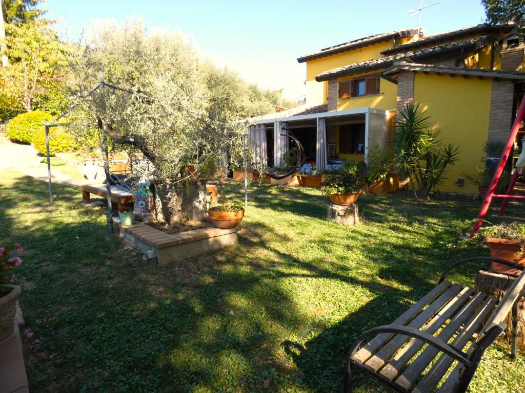 une cour avec un banc devant une maison dans l'établissement Scappo in Umbria, Eva, à Fornole