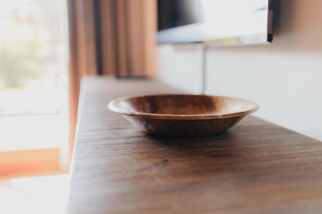 un bol en bois assis au-dessus d'une table en bois dans l'établissement Casa Bo, à Montgenèvre