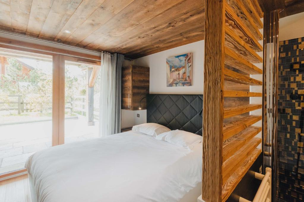 une chambre avec un lit et une grande fenêtre dans l'établissement Casa Bo, à Montgenèvre