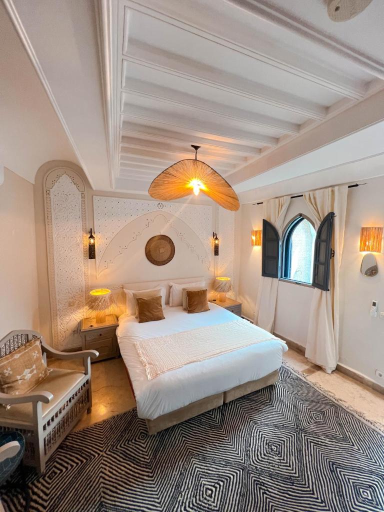 une chambre avec un grand lit et une chaise dans l'établissement Riad Jonan & Spa, à Marrakech