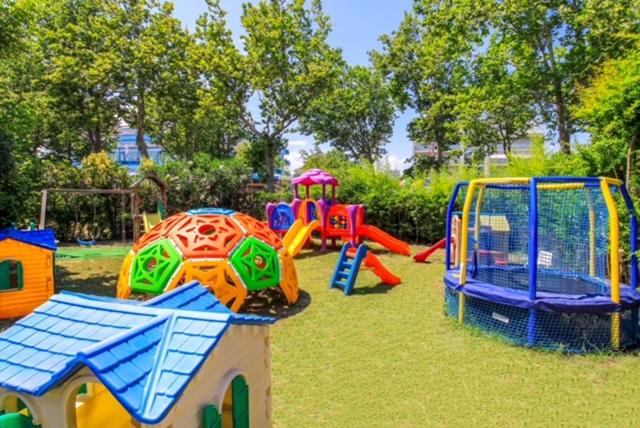 une aire de jeux avec des équipements de jeu colorés dans un parc dans l'établissement Hotel Duca di Kent, à Cesenatico