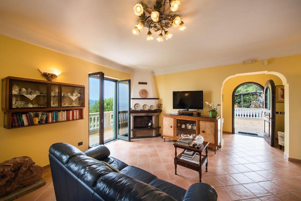 un salon avec un canapé en cuir et une télévision dans l'établissement Villa Turtle, à Massa Lubrense