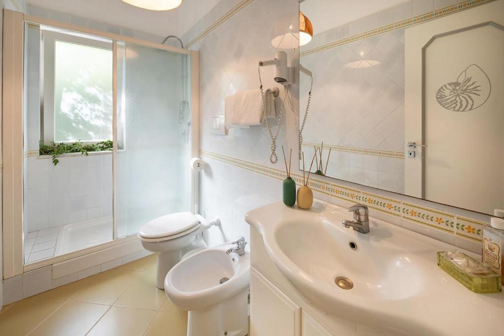une salle de bain avec un lavabo, des toilettes et un miroir dans l'établissement Villa Marinella close to the sea with private pool, à Nerano 26 autres photos